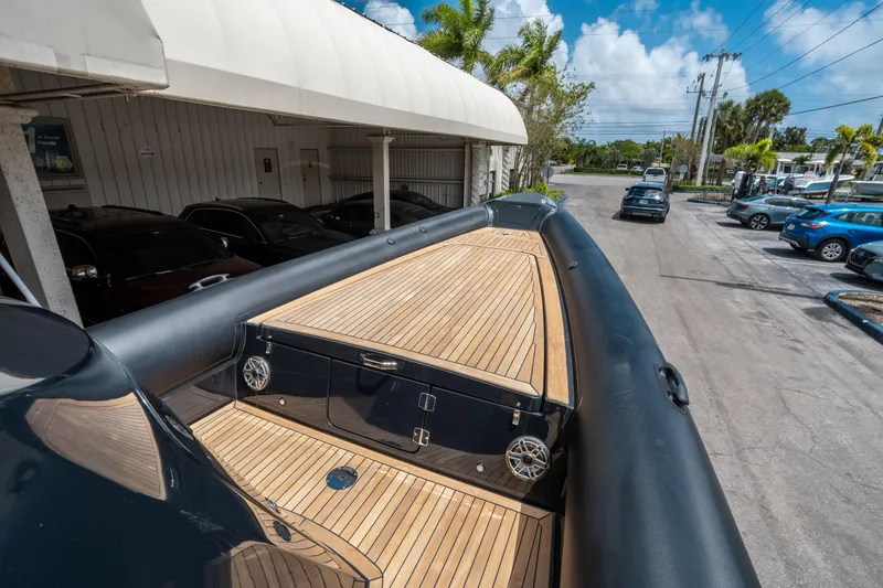 Slide: The Image of 2023 Ribco Seafarer 36 X boat with sleek wooden deck, parked outdoors. - 39