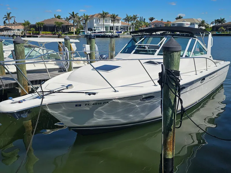 Slide: The Image of 2000 Tiara Yachts 3100 Open docked in a marina with waterfront homes. - 1