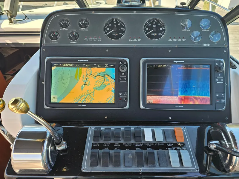 Slide: The Image of Control panel of a 2000 Tiara Yachts 3100 Open with navigation displays. - 12