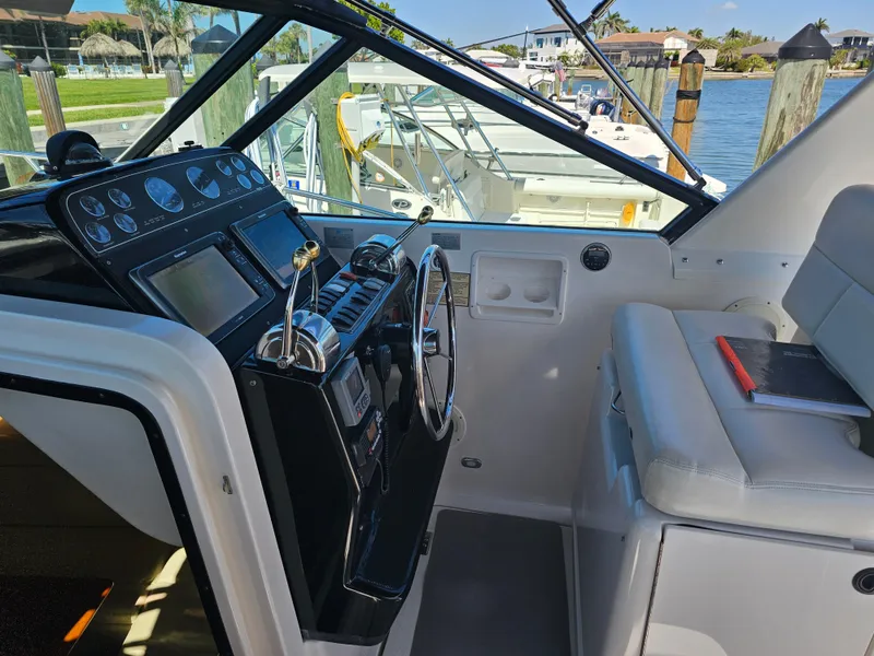 Slide: The Image of Cockpit of 2000 Tiara Yachts 3100 Open with steering wheel and control panel. - 14
