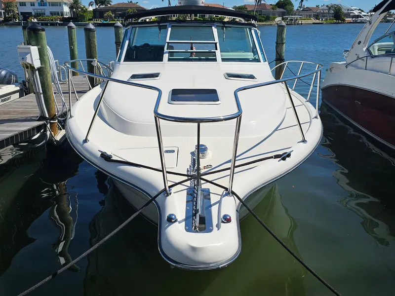 Slide: The Image of 2000 Tiara Yachts 3100 Open docked, front view, in a marina setting. - 2