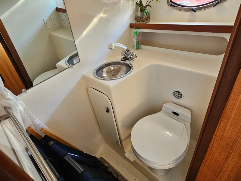 Slide: The Image of Compact bathroom in a 2000 Tiara Yachts 3100 Open, featuring a sink and toilet. - 23