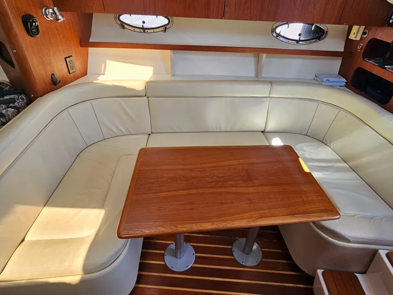 Slide: The Image of 2000 Tiara Yachts 3100 Open interior with cream seating and wooden table. - 24