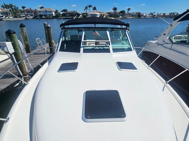 Slide: The Image of 2000 Tiara Yachts 3100 Open docked, showcasing sleek design and spacious deck. - 3