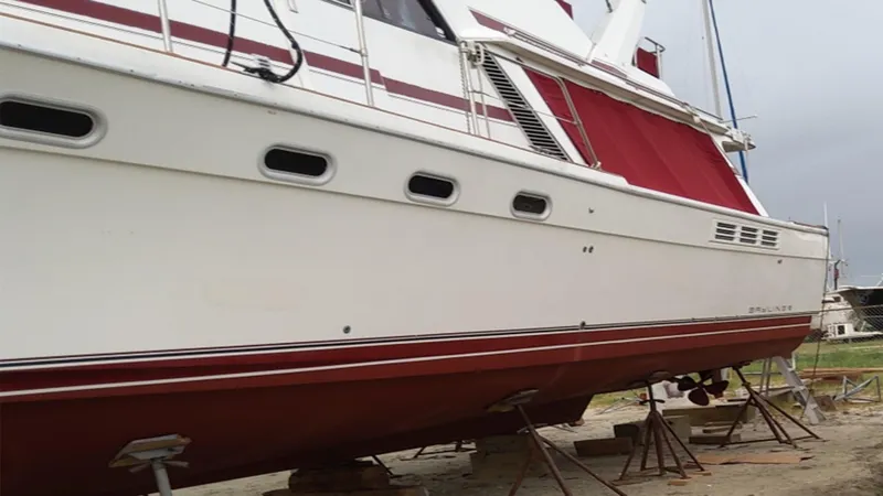 Slide: The Image of 1991 Bayliner 4588 Motoryacht on dry dock, white and red exterior, side view. - 7