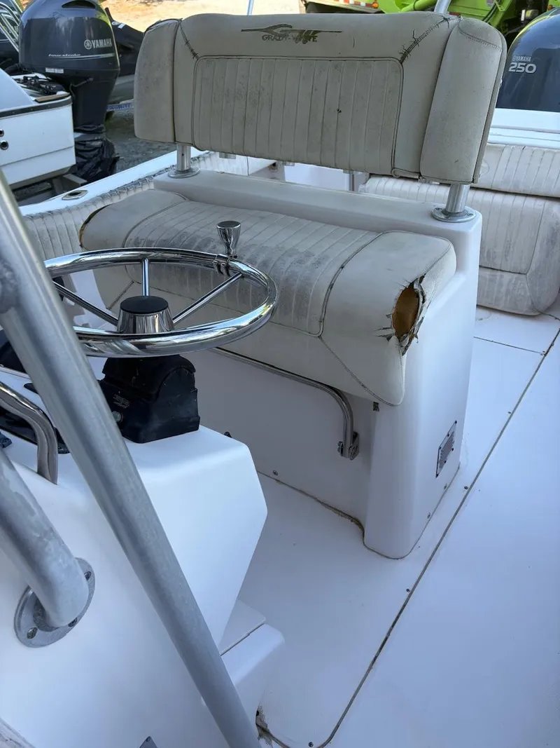 Slide: The Image of 2003 Grady-White Advance 257 boat interior with worn seating and steering wheel. - 5