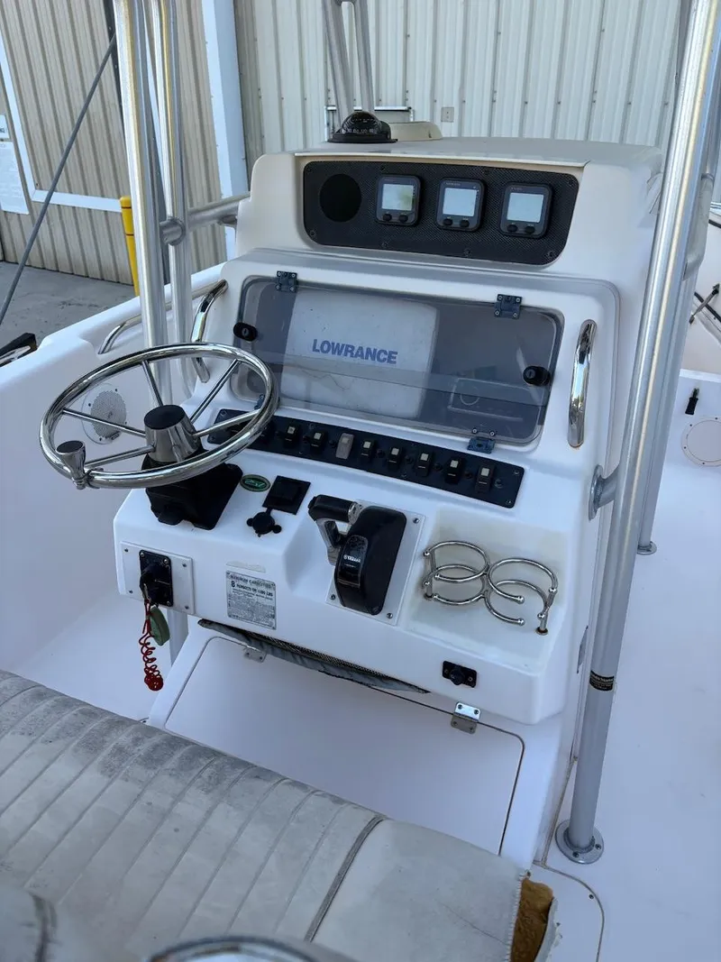 Slide: The Image of 2003 Grady-White Advance 257 boat console with steering wheel and navigation controls. - 8