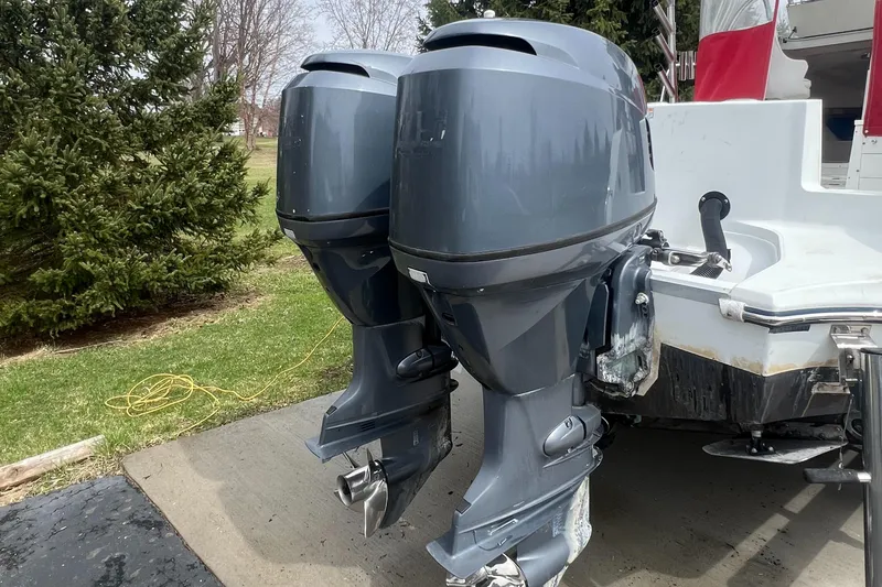 Slide: The Image of Twin outboard motors on a 2006 Polar 2300 Walkaround boat, parked outdoors. - 2