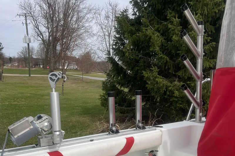 Slide: The Image of 2006 Polar 2300 Walkaround boat with rod holders, set against a grassy landscape. - 5