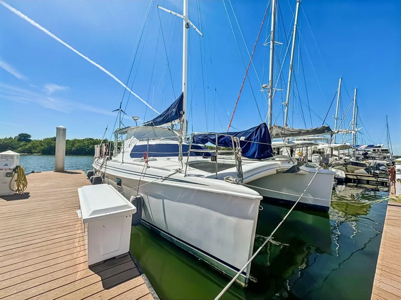 The Image of 2000 Manta 42 catamaran docked at marina under clear blue sky. - 0