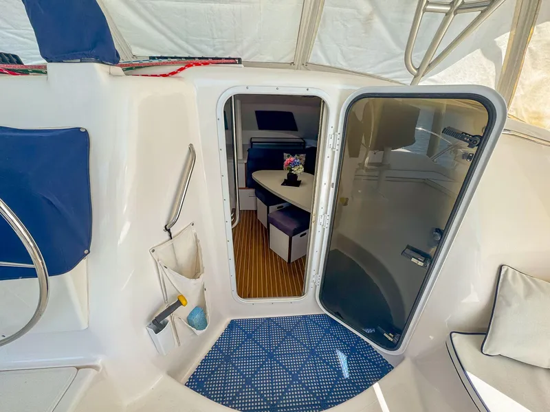 Slide: The Image of 2000 Manta 42 yacht interior with open door, showing seating and table. - 18