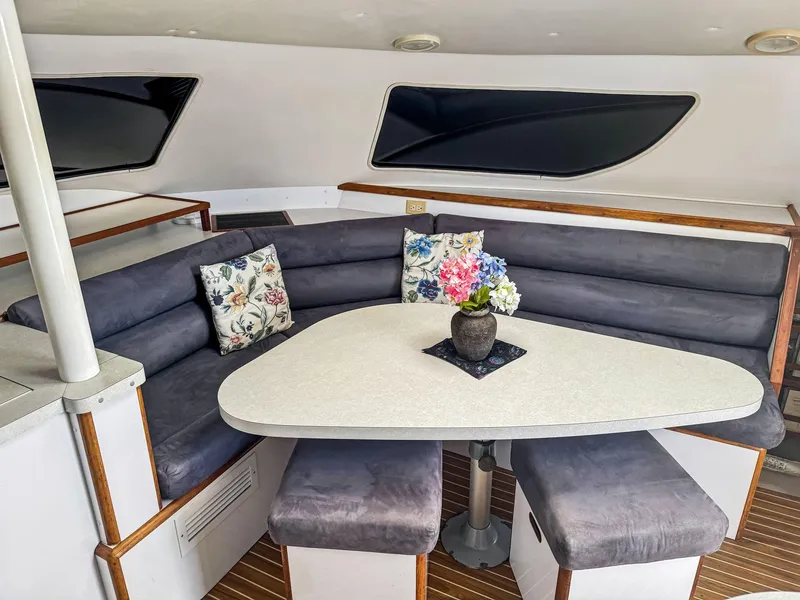 Slide: The Image of Cozy dining area in a 2000 Manta 42 yacht with floral decor and cushioned seating. - 20