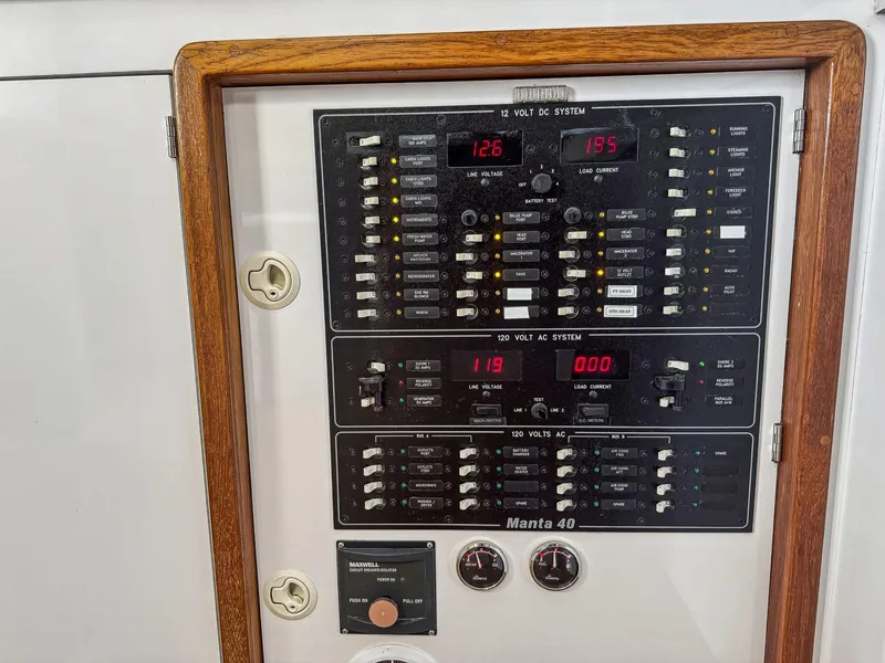 Slide: The Image of Electrical panel of a 2000 Manta 42 boat with wooden frame. - 24