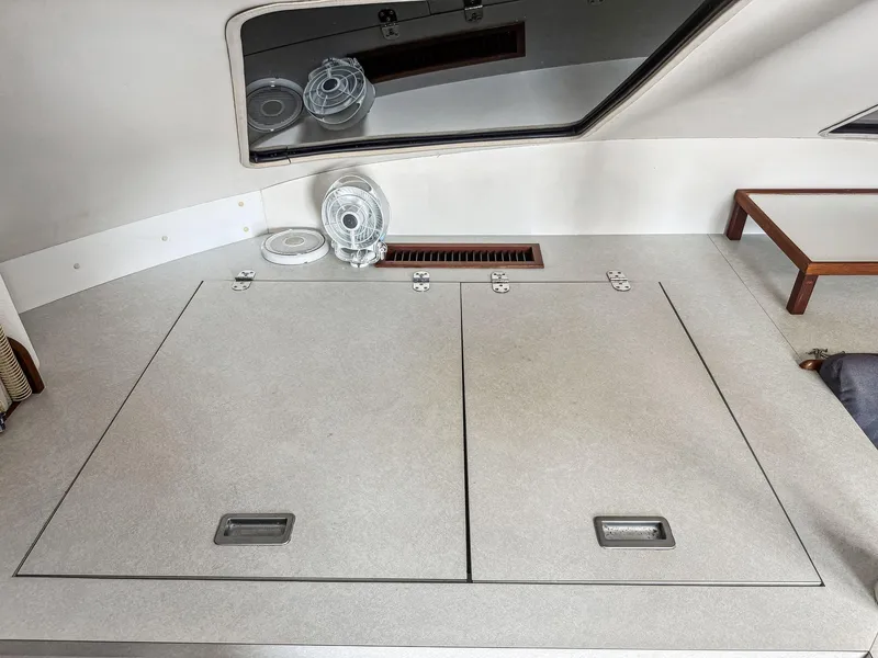 Slide: The Image of Interior of a 2000 Manta 42 catamaran with storage compartments and a mirror. - 25