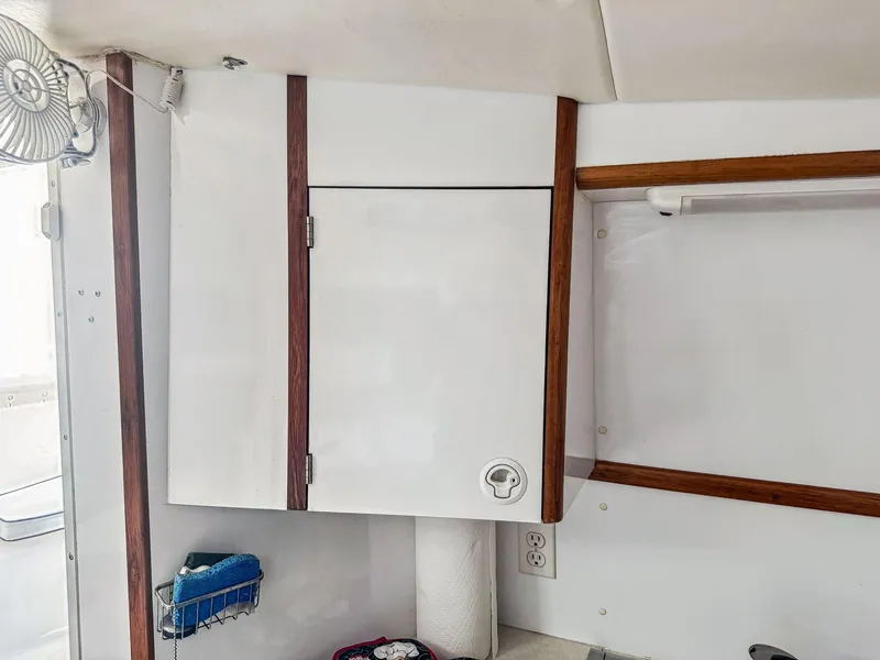 Slide: The Image of Interior of a 2000 Manta 42 boat showing a white cabinet with wooden trim. - 28