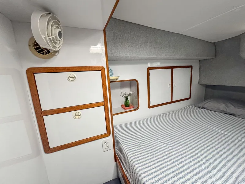 Slide: The Image of Cozy cabin interior of 2000 Manta 42 yacht with striped bedding and wooden storage. - 38
