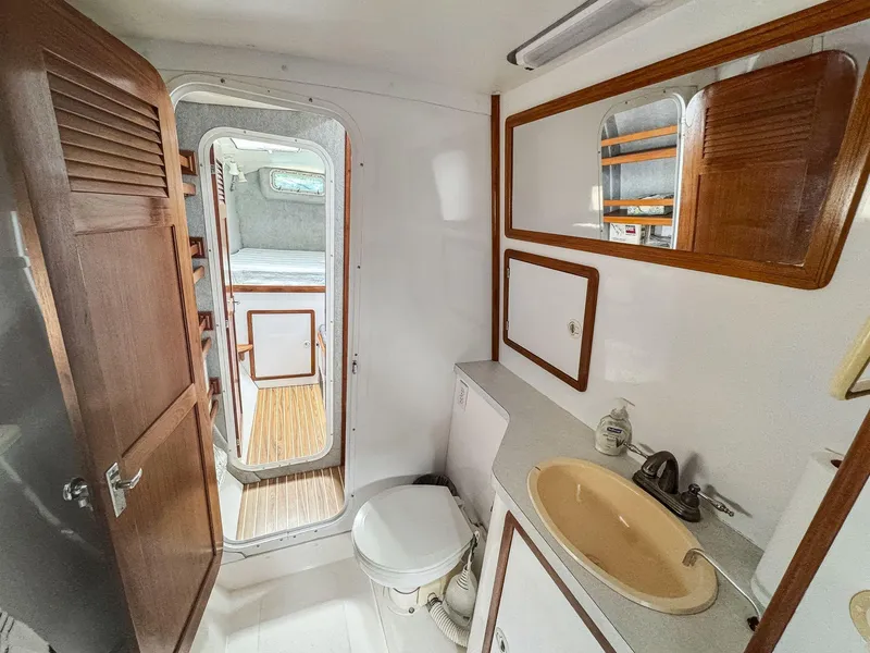 Slide: The Image of Bathroom interior of 2000 Manta 42 yacht, featuring sink, toilet, and wooden accents. - 48