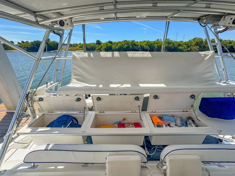 Slide: The Image of Manta 42 sailboat deck with open storage compartments, docked by a scenic waterway. - 7