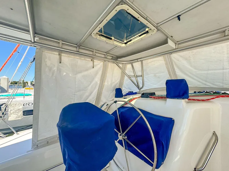Slide: The Image of Interior view of a 2000 Manta 42 sailboat cockpit with blue-covered seats and steering wheel. - 9