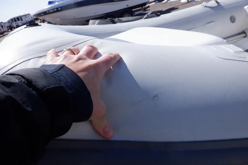 Slide: The Image of Hand inspecting Walker Bay Odyssey 325 ST inflatable boat, 2015 model, in outdoor setting. - 36