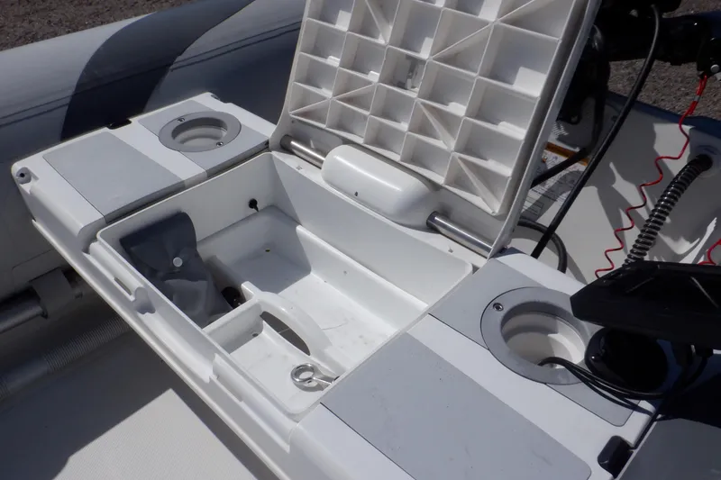 Slide: The Image of Walker Bay Odyssey 325 ST 2015 boat storage compartment with cup holders and open lid. - 39