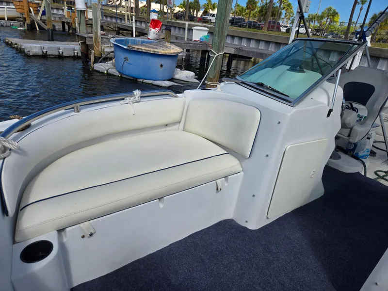 Slide: The Image of 2003 Glacier Bay 2240 SX Renegade boat with white seating and windshield at a marina. - 5