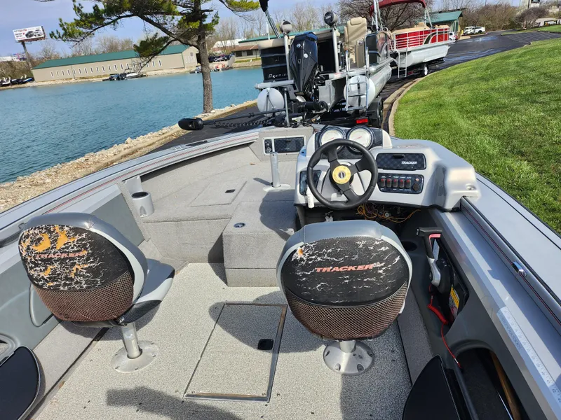 Slide: The Image of 2007 Tracker Targa 175 SC boat interior with steering wheel and seating near a lake. - 11