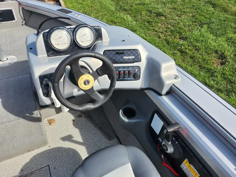 Slide: The Image of 2007 Tracker Targa 175 SC boat dashboard with steering wheel and gauges, parked on grass. - 14