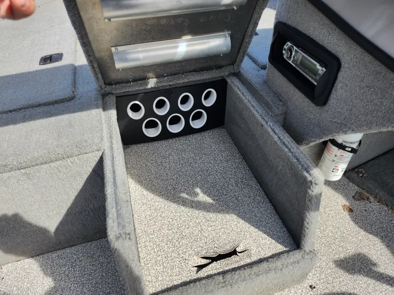 Slide: The Image of 2007 Tracker Targa 175 SC boat storage compartment with cup holders and carpeted interior. - 18