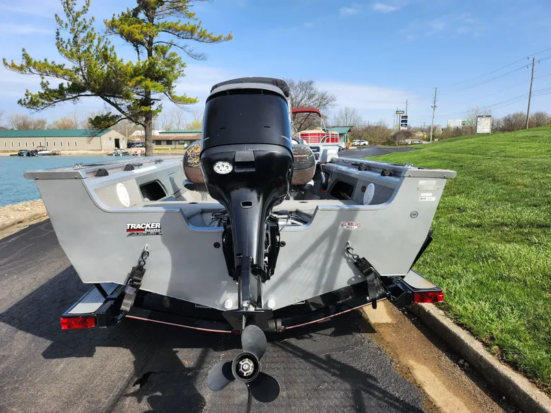 Slide: The Image of 2007 Tracker Targa 175 SC boat with outboard motor, parked near a lake on a sunny day. - 2