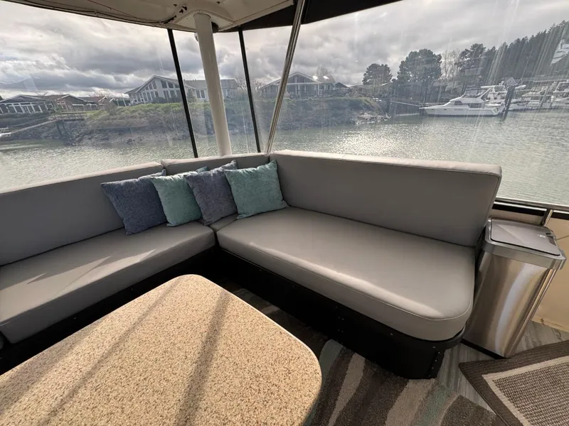 Slide: The Image of 1989 Prima 52 Cockpit Motor Yacht interior with gray seating and scenic waterfront view. - 15