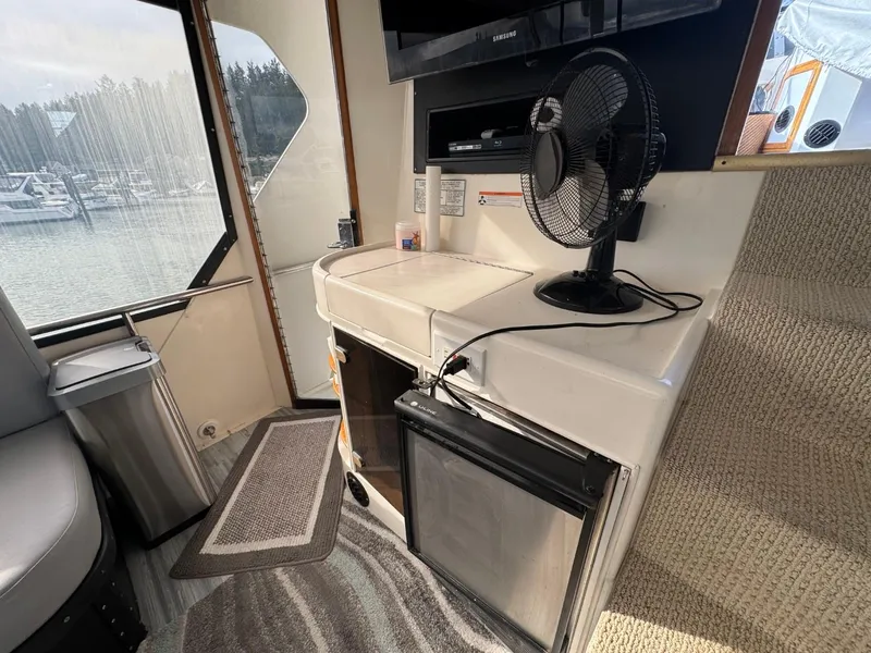 Slide: The Image of Interior of 1989 Prima 52 Cockpit Motor Yacht with fan, fridge, and window view. - 17