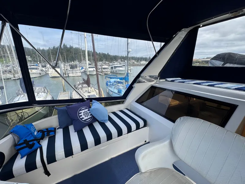 Slide: The Image of Cockpit view of 1989 Prima 52 Motor Yacht with striped seating and marina backdrop. - 31
