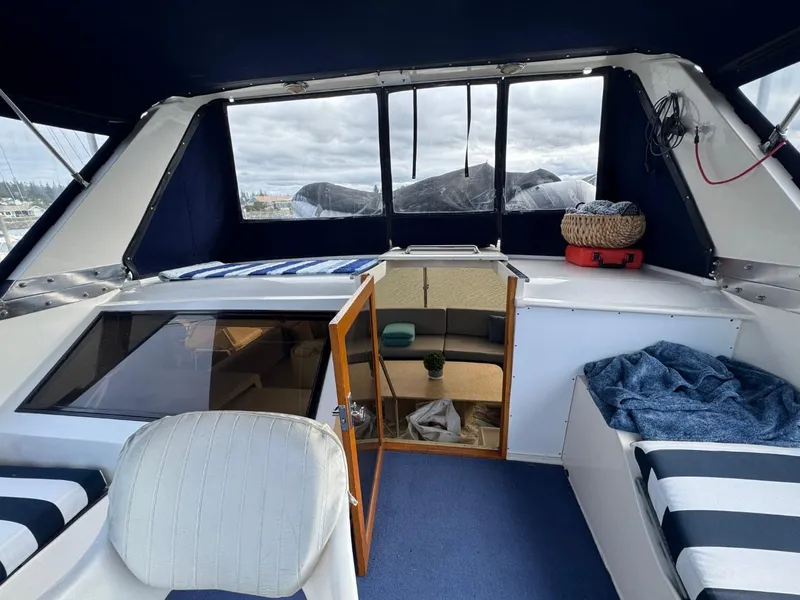 Slide: The Image of 1989 Prima 52 Cockpit Motor Yacht interior with seating and open cabin door. - 33