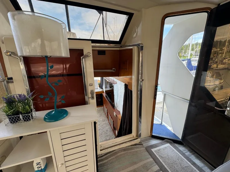 Slide: The Image of 1989 Prima 52 Cockpit Motor Yacht interior with lamp, cabinet, and open door to deck. - 34