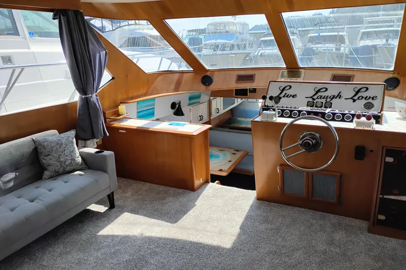 Slide: The Image of 1989 Prima 52 Cockpit Motor Yacht interior with helm, sofa, and nautical decor. - 36