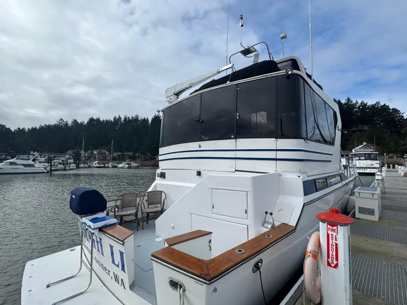 Slide: The Image of 1989 Prima 52 Cockpit Motor Yacht docked at a marina with scenic background. - 4