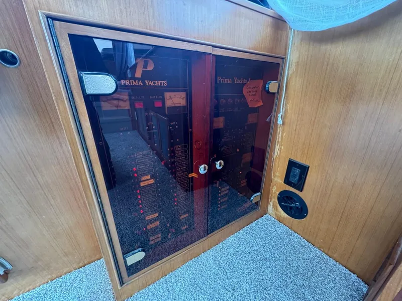 Slide: The Image of 1989 Prima 52 Cockpit Motor Yacht control panel with wooden finish and carpeted floor. - 46