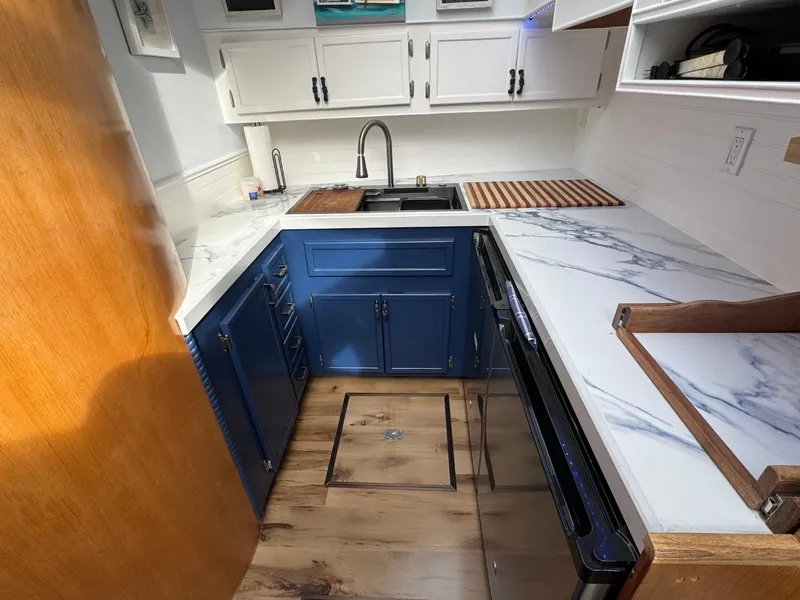 Slide: The Image of 1989 Prima 52 Cockpit Motor Yacht kitchen with blue cabinets and marble countertops. - 47
