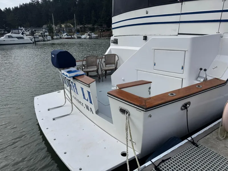 Slide: The Image of 1989 Prima 52 Cockpit Motor Yacht docked, featuring spacious deck and seating area. - 5