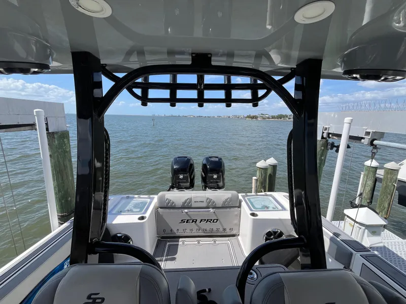 Slide: The Image of 2022 Seapro 320 DLX boat interior with dual engines, docked by the water. - 11