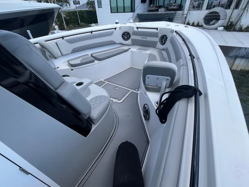 Slide: The Image of 2022 Seapro 320 DLX boat interior with seating and speakers, docked near modern house. - 16