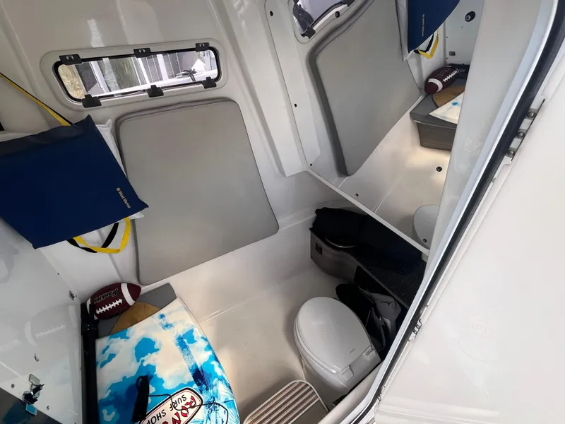 Slide: The Image of 2022 Seapro 320 DLX cabin interior with seating, storage, and marine toilet. - 18