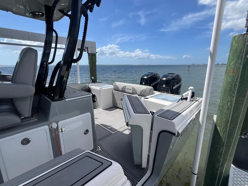 Slide: The Image of 2022 Seapro 320 DLX boat docked by the sea, featuring dual engines and spacious seating. - 21