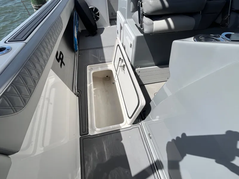 Slide: The Image of 2022 Seapro 320 DLX boat interior with open storage compartment and seating. - 22