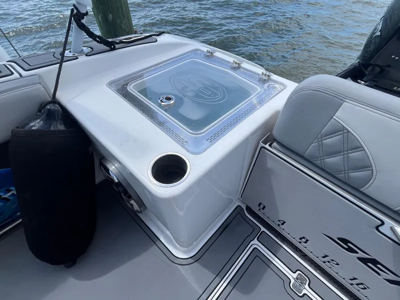 Slide: The Image of 2022 Seapro 320 DLX boat interior with seating and storage, docked by the water. - 24