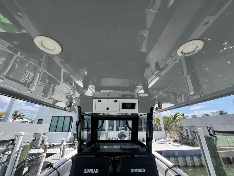 Slide: The Image of 2022 Seapro 320 DLX boat interior with Simrad equipment, docked near modern waterfront homes. - 29