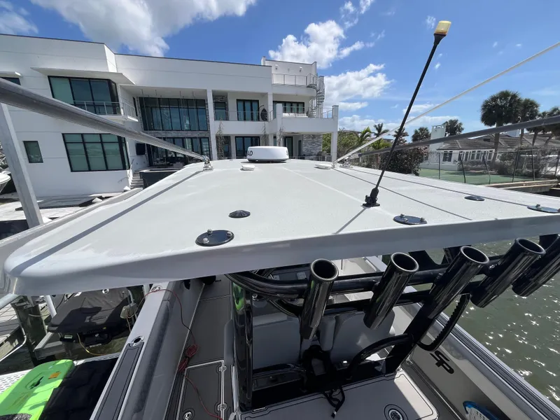 Slide: The Image of 2022 Seapro 320 DLX boat docked near modern waterfront home under blue sky. - 30