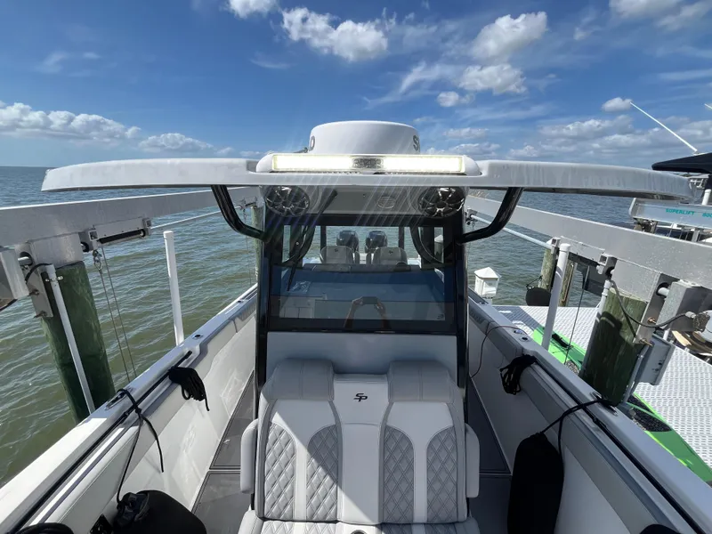 Slide: The Image of 2022 Seapro 320 DLX boat with sleek design, docked under a clear blue sky. - 31