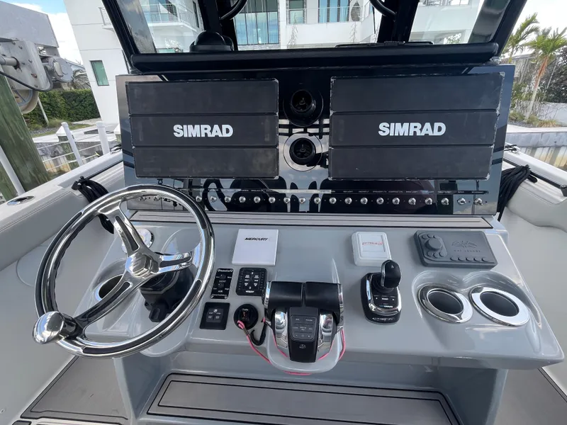 Slide: The Image of 2022 Seapro 320 DLX boat dashboard with dual Simrad displays and modern controls. - 8
